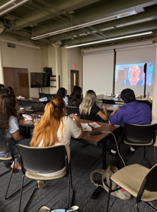 Attendees listening to a message from Carolyn Kallenborn at the screening of Woven Lives.